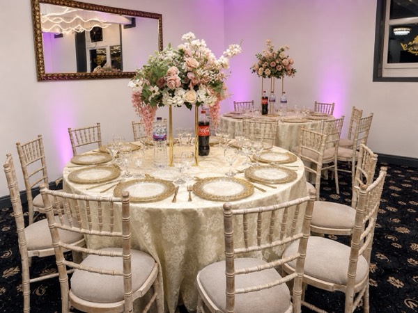 Blush florals and gold place settings dressed for a wedding at Green Lane Banqueting
