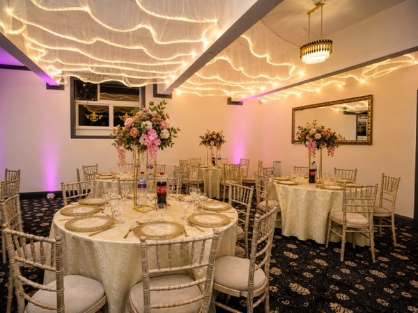 Floral centrepieces under the chandelier at Green Lane Banqueting
