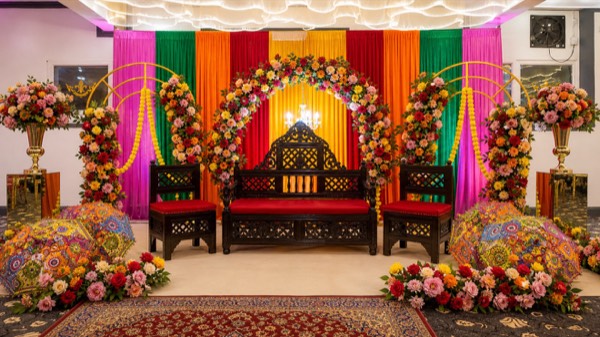 A vibrant marigold mehndi stage styled at Green Lane Banqueting